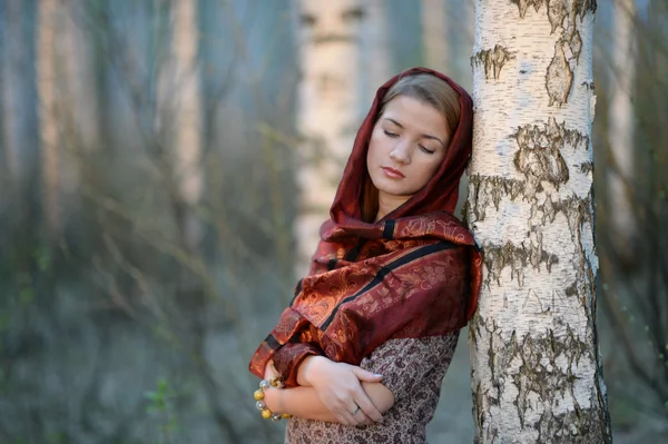 Orosz lány egy sálat, nyír erdőben, közelkép — Stock Fotó