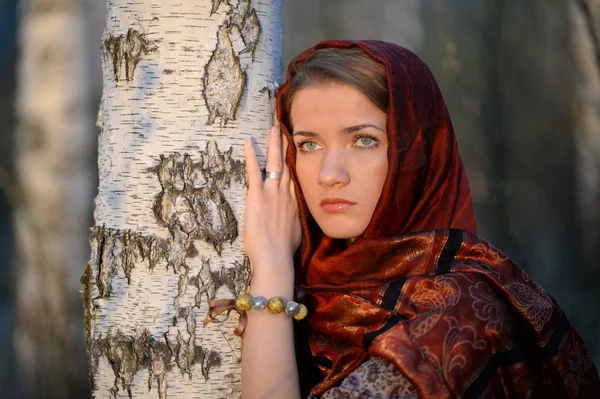 Russian girl in a scarf in a birch forest — Stock Photo, Image