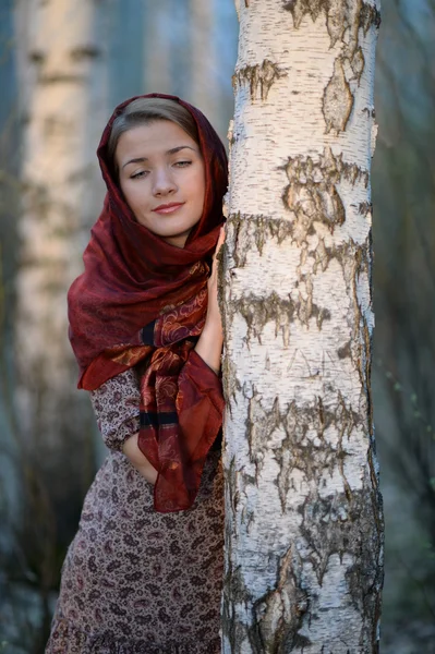 Menina russa em um lenço em uma floresta de vidoeiro — Fotografia de Stock