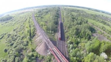 Tren geçerken demiryolu parça (Üstgeçit Köprüsü) üst quadrocopters görüntüleyin. Rusya