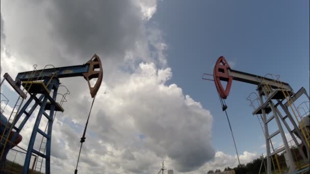 Bombas de aceite. Equipo de la industria petrolera. Nubes de tormenta. cámara móvil — Vídeo de stock