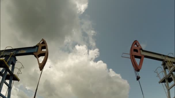 Bombas de aceite. Equipo de la industria petrolera. Nubes de tormenta. cámara móvil — Vídeo de stock