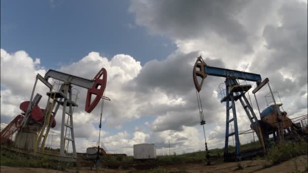 Bombas de aceite. Equipo de la industria petrolera. Nubes de tormenta. cámara móvil — Vídeos de Stock