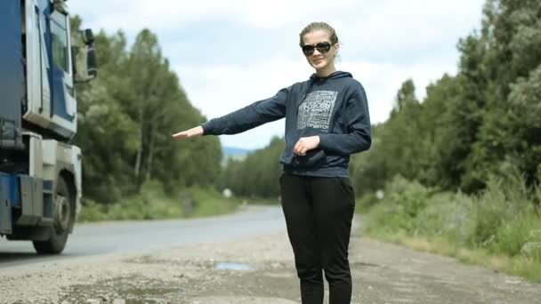 Chica joven tratando de detener el coche en la carretera — Vídeo de stock