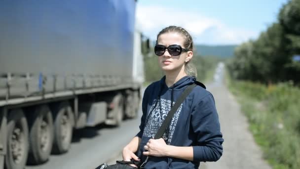 Giovane ragazza cercando di fermare la macchina sulla strada — Video Stock