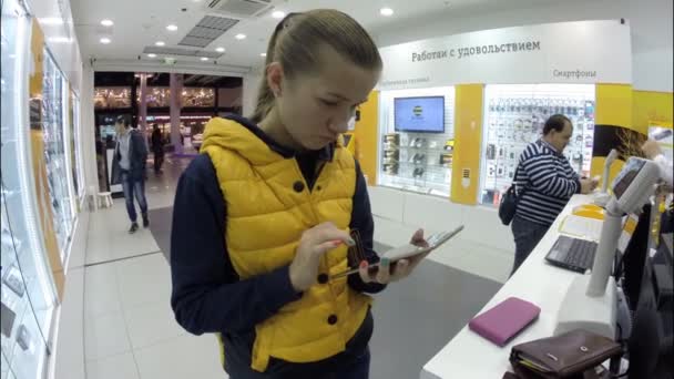 Chica feliz compra una tableta dentro del Beeline — Vídeo de stock