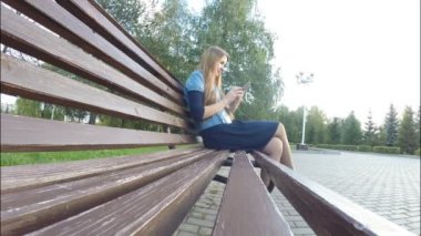 Tablet bilgisayar sonbahar parkta okuma kız