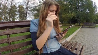 Tablet bilgisayar sonbahar parkta okuma kız