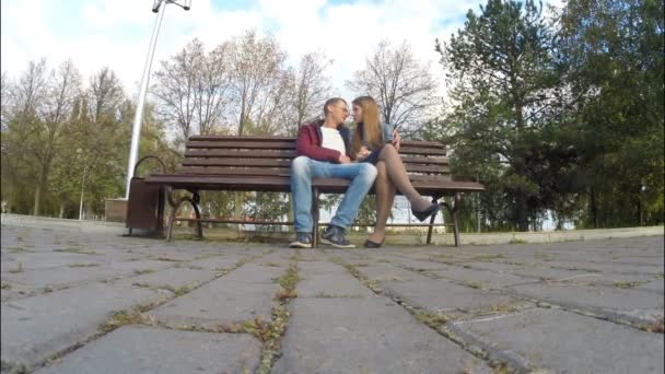 Uomo e donna nel parco autunnale su una panchina — Video Stock