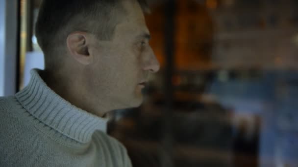 Arka plan bir akşam street, arabalar ve ışık üstünde belgili tanımlık pencere yanında depresif adam — Stok video