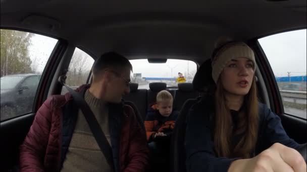 Familie van drie mensen die door de stad in een auto reizen. Moeder, vader, zoon — Stockvideo