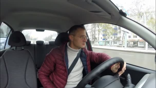 Man rider runt stan i en bil. Den ryska staden, höst, vinter. — Stockvideo