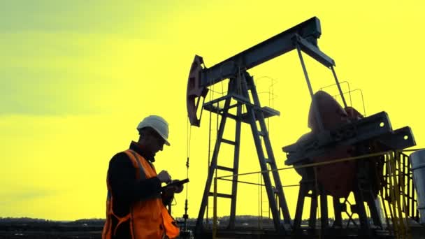 Uomo (Ingegnere, Manager, Supervisore, petroliere) con tablet controlla l'unità di pompaggio dell'olio . — Video Stock