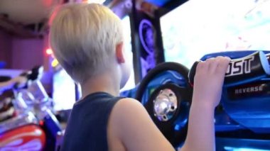 Lunaparkta slot makinesi oynayan bir çocuk.