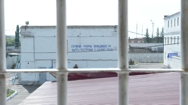 罰則のシステムでバーの後ろの刑務所の窓からの典型的な風景 — ストック動画