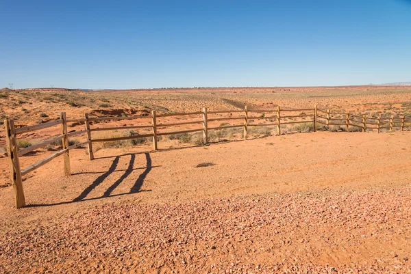 Old wooden fence in the sandy desert — Stock Photo, Image