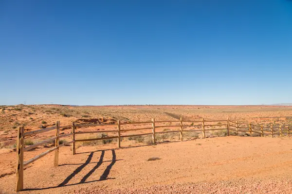 Old wooden fence in the sandy desert — Stock Photo, Image