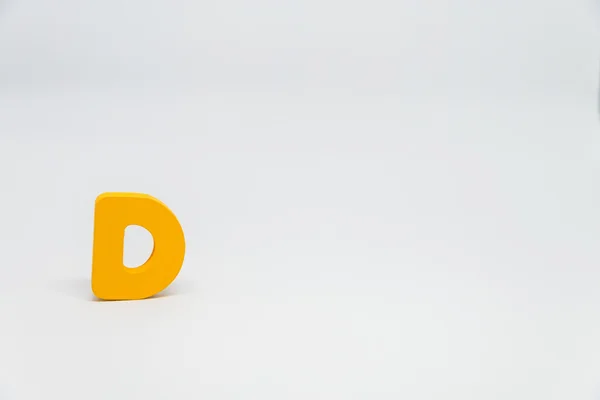 Yellow Wooden alphabet D with white background — Stock Photo, Image