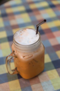 Seçici odak kulplu küp cam saman ile buz süt çay