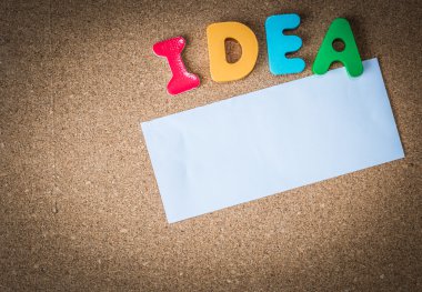 Renkli ahşap kelime beyaz kağıt parçası ile fikri üzerine mantar pano