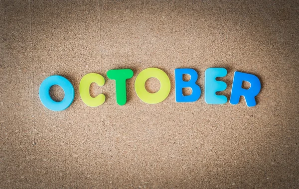 Πολύχρωμο ξύλινο λέξη Οκτώβριος στο πίνακα φελλού με επιλεκτική εστίαση — Φωτογραφία Αρχείου