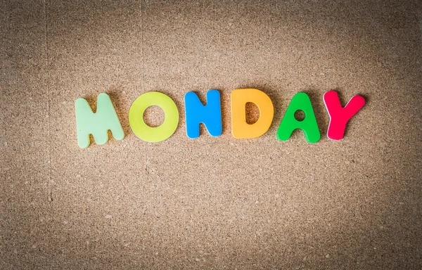 Colorful wooden word MONDAY on Cork board with selective focus — Stock Photo, Image