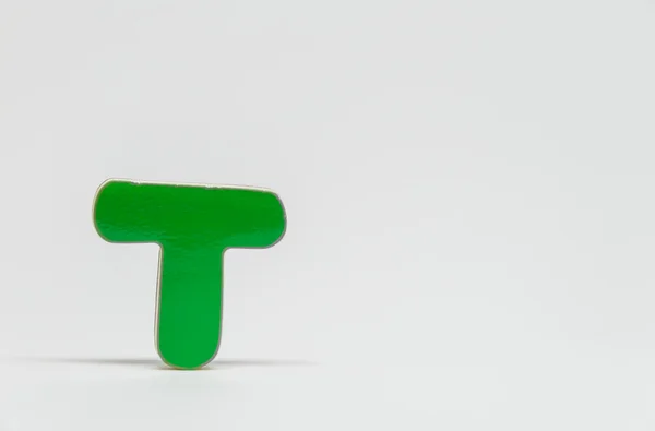 Zielony drewniane alfabet T z białym tłem i Selektywny fokus — Zdjęcie stockowe