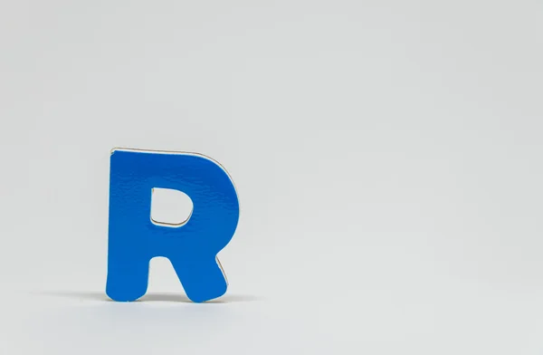 Blue wooden alphabet R with white background and selective focus — Stock Photo, Image