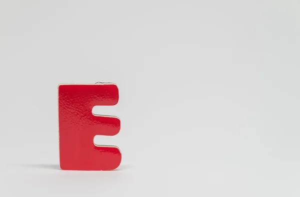 Red wooden alphabet E with white background and selective focus — Stock Photo, Image