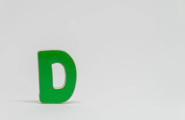 Green wooden alphabet D with white background and selective focus — Stock Photo, Image