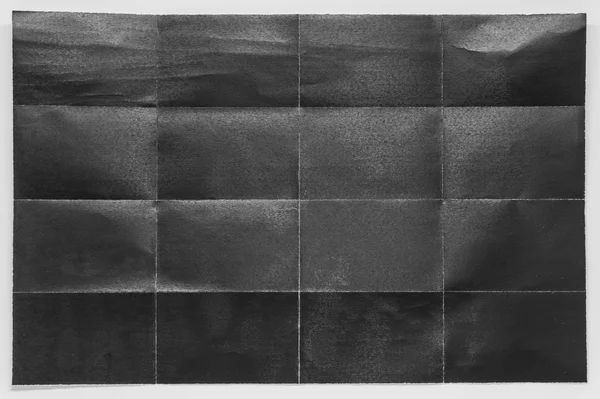 Papel preto dobrado em 16 partes com fundo branco — Fotografia de Stock