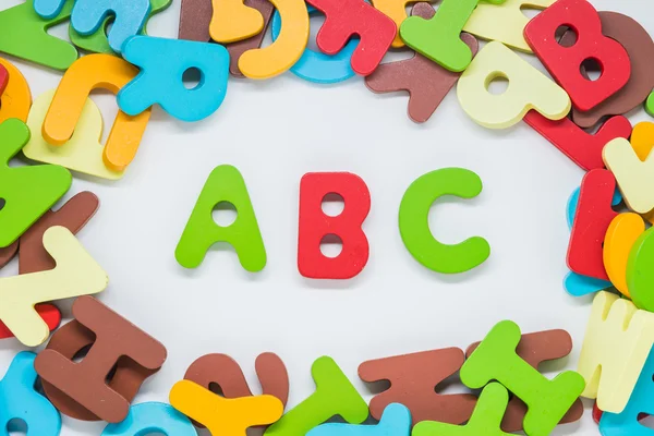 Carácter de madera colorido con fondo blanco y palabra ABC en el medio — Foto de Stock