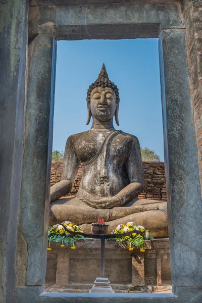 Pohled na sedící Buddha socha kamenných dveří v starověký chrám v Thajsku — Stock fotografie