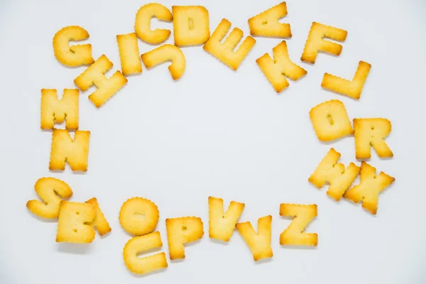 Cracker alfabeto com espaço no meio em fundo branco — Fotografia de Stock