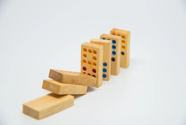 Colapso de dominó de madera sobre fondo blanco con enfoque selectivo —  Fotos de Stock