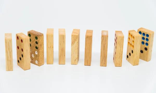 Secuencia de dominó de madera sobre fondo blanco con enfoque selectivo —  Fotos de Stock