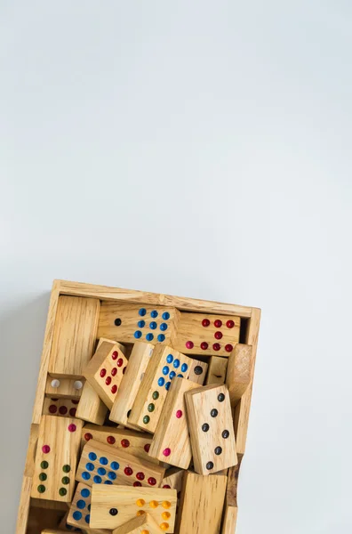 Деревянные домино в деревянной коробке на белом фоне с избирательным фокусом — стоковое фото