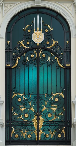 Porte classique en acier noir et or de style européen avec bâtiment blanc — Photo