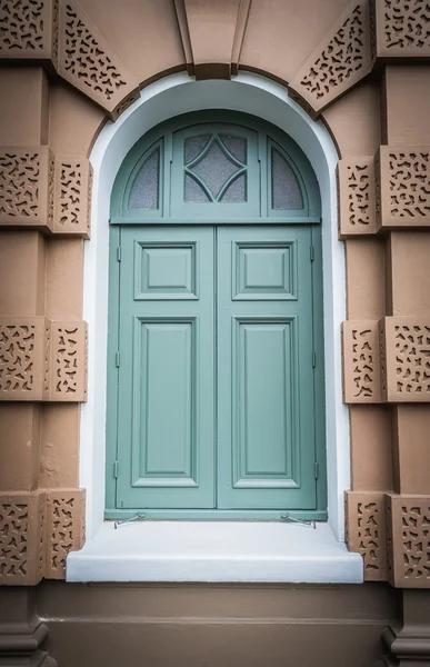 Janela de madeira verde fechada em estilo europeu com edifício Brown — Fotografia de Stock