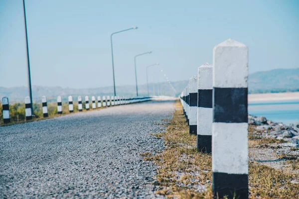 农村的道路上 一排排黑白相间的柱子形成了旅游理念 — 图库照片