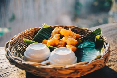 Bol yağda kızartılmış hamur, muz yaprağının üzerinde bambu sepeti ve ahşap tahtada kahvaltı yemeği için sabah yumuşak güneş ışığıyla birlikte sabahleyin