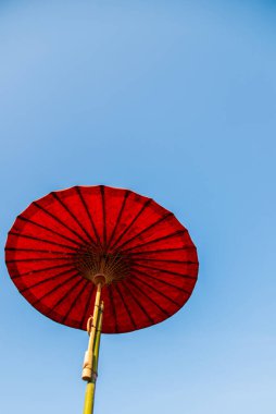 Tayland usulü açık mavi gökyüzü ile kırmızı el yapımı kağıt şemsiye altında