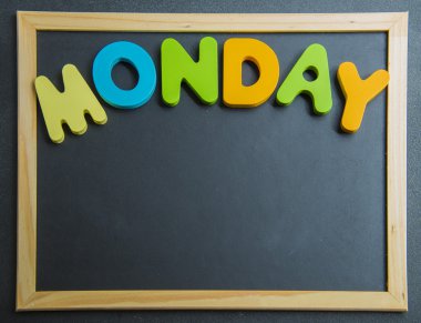kolorowe drewniane słowo poniedziałek na czarny deska