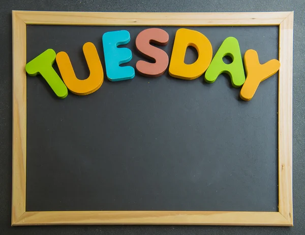 Kleurrijke houten woord dinsdag op zwarte bord — Stockfoto