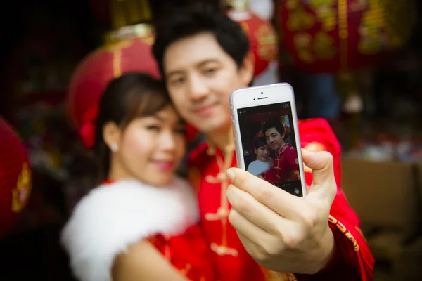 Piękna para selfie Zdjęcie przez smartphone z czerwonego papieru chiński — Zdjęcie stockowe