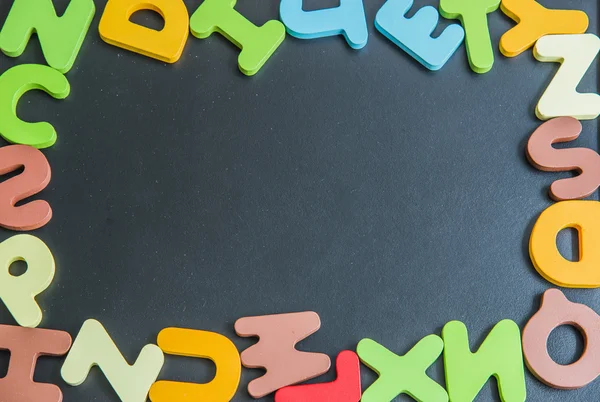黒 board4 にカラフルな木製単語をアルファベットをミックスします。 — ストック写真