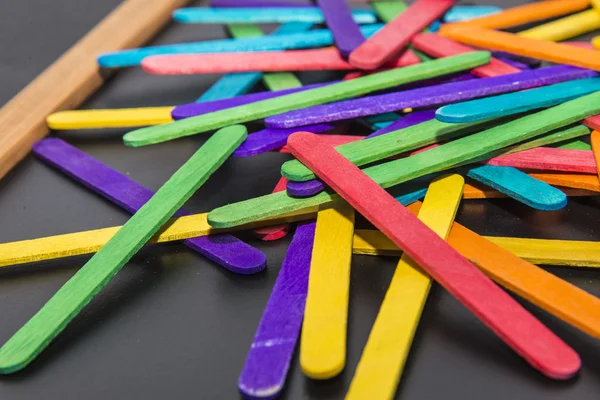 Holzstreifen in verschiedenen Farben auf schwarzem Brett 4 — Stockfoto