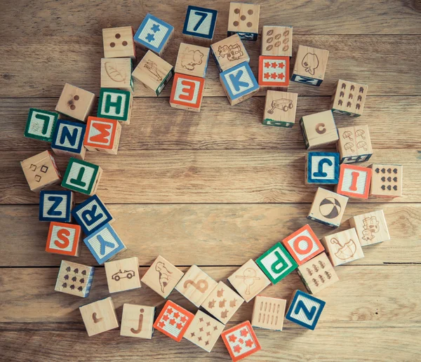 Houten blok alfabet lag op houten vloer in cirkel vorm — Stockfoto