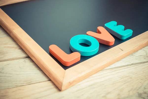 Dřevěná slovo láska na rohu černé desky 4 — Stock fotografie