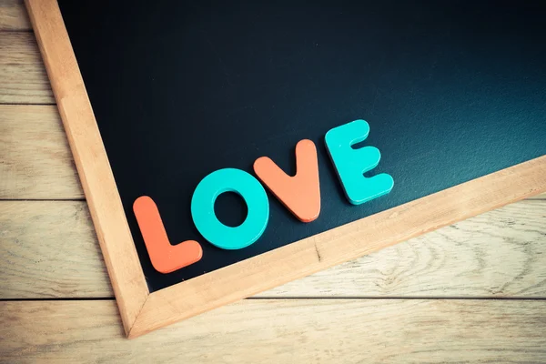 Wooden word LOVE on Black board 4 — Stock Photo, Image